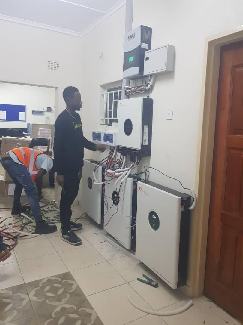 Engineers installing solar inverter and battery system