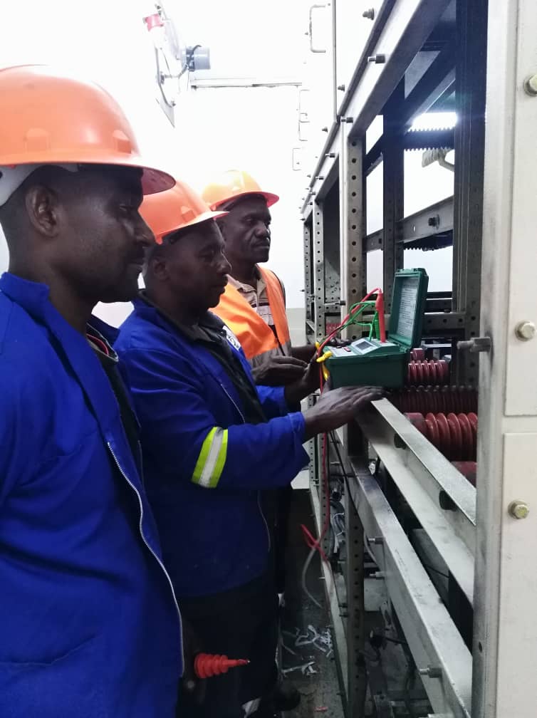 Engineers testing switchgear with instruments