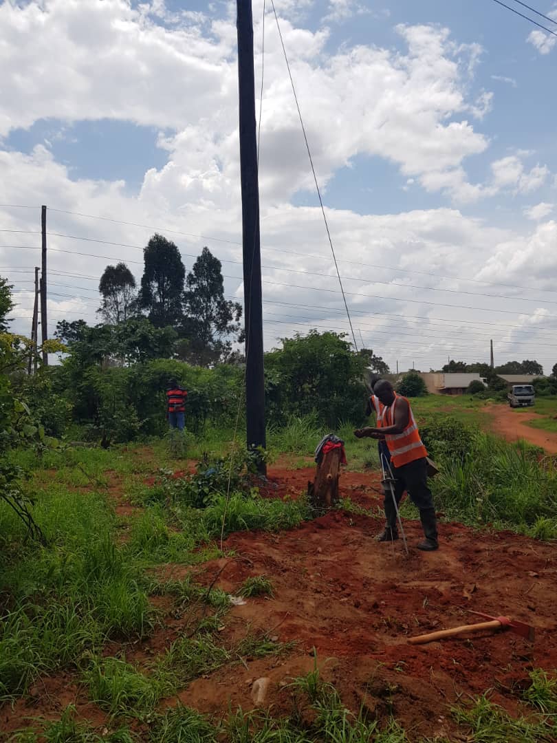 Worker surveying pole installation site